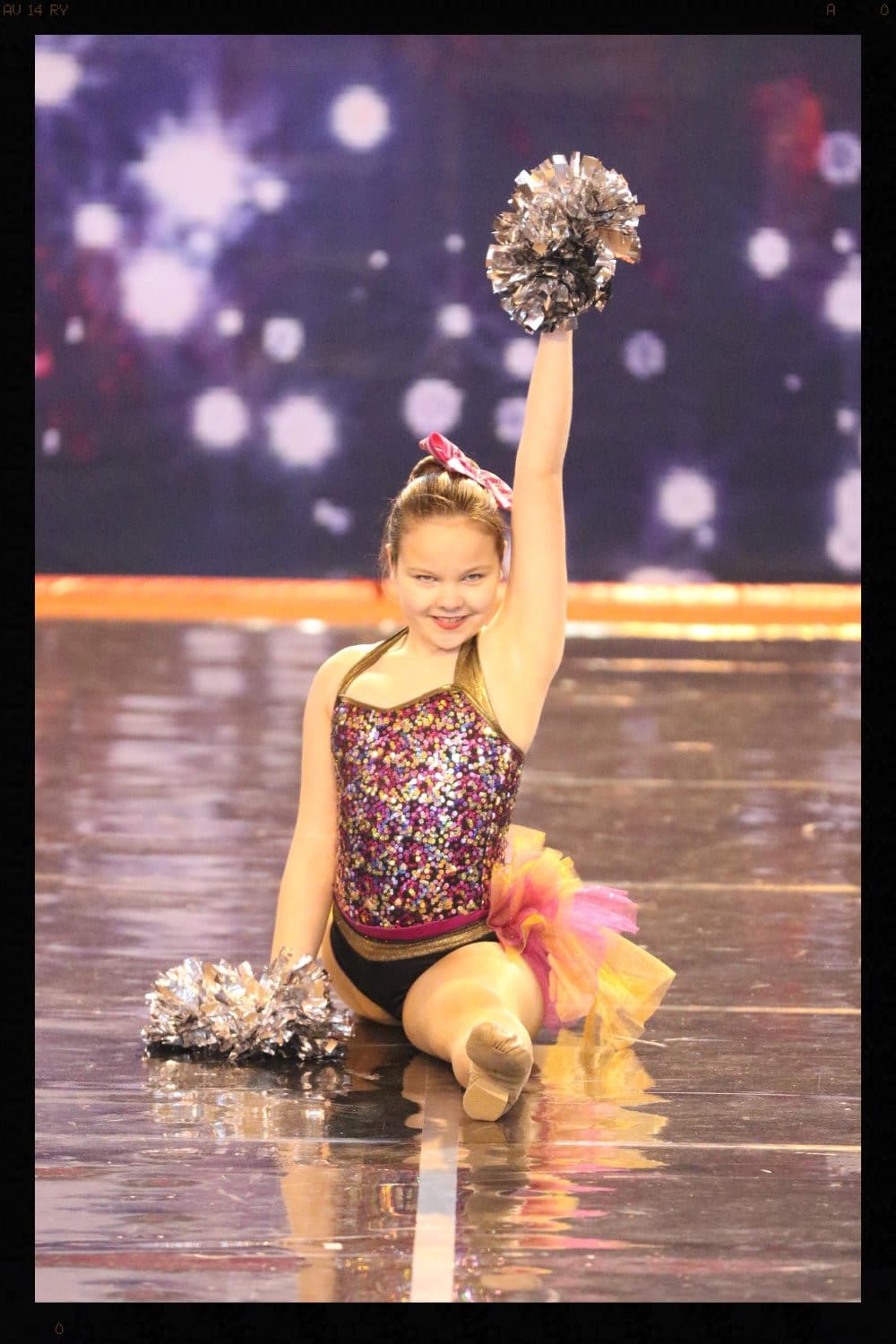 Young dancer in sequins with pom-poms