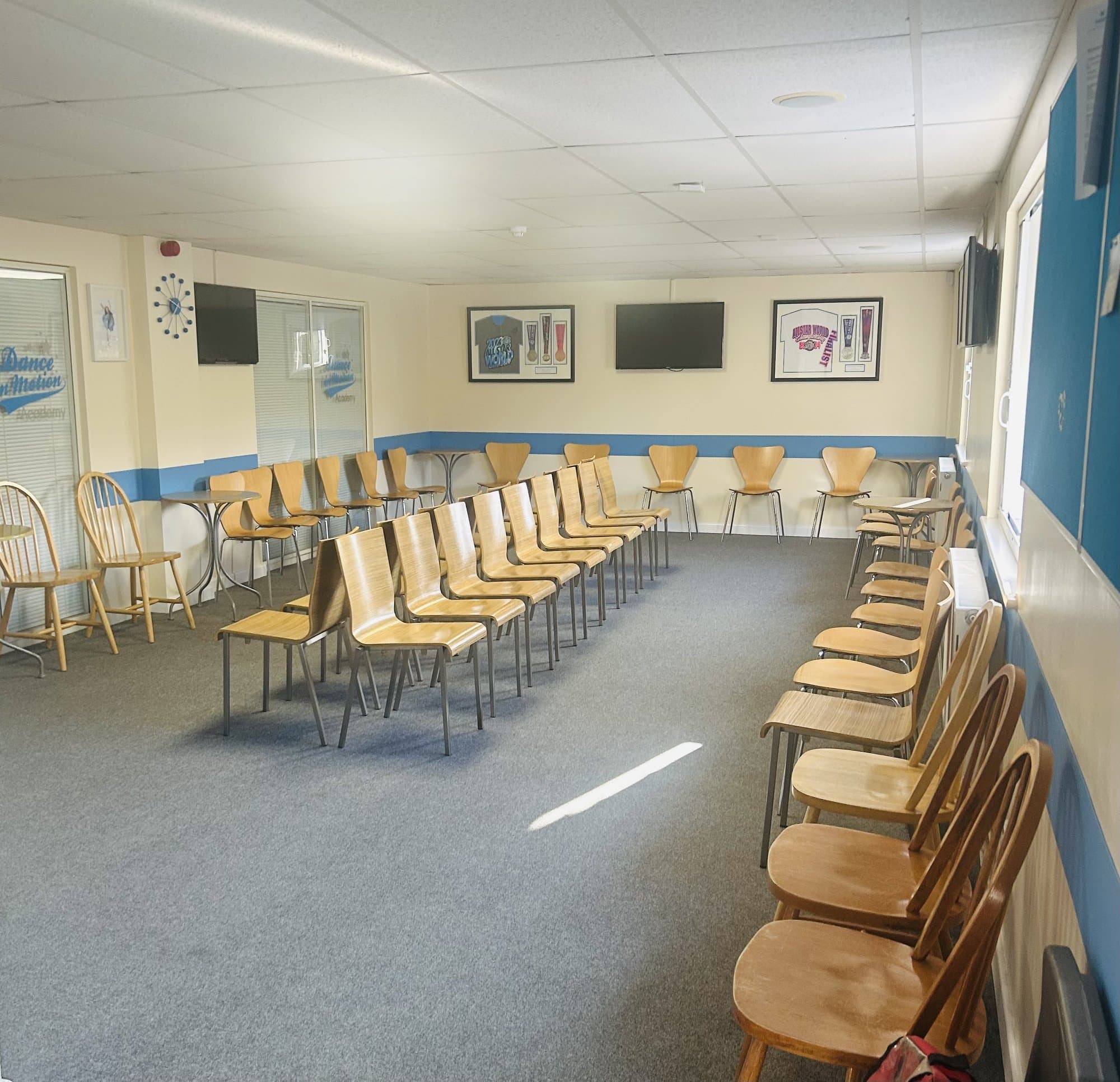 Family waiting area with seating, tables and live viewing screens